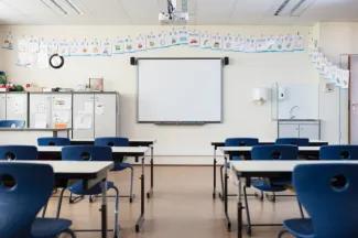 Empty Classroom with blue chairs and a whiteboard